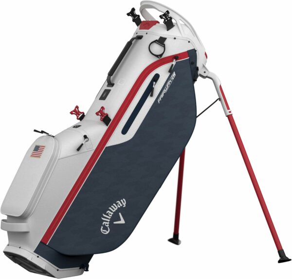 Callaway stand golf bag featuring foldable red legs, navy blue and white design with red accents, multiple compartments, and an American flag decoration